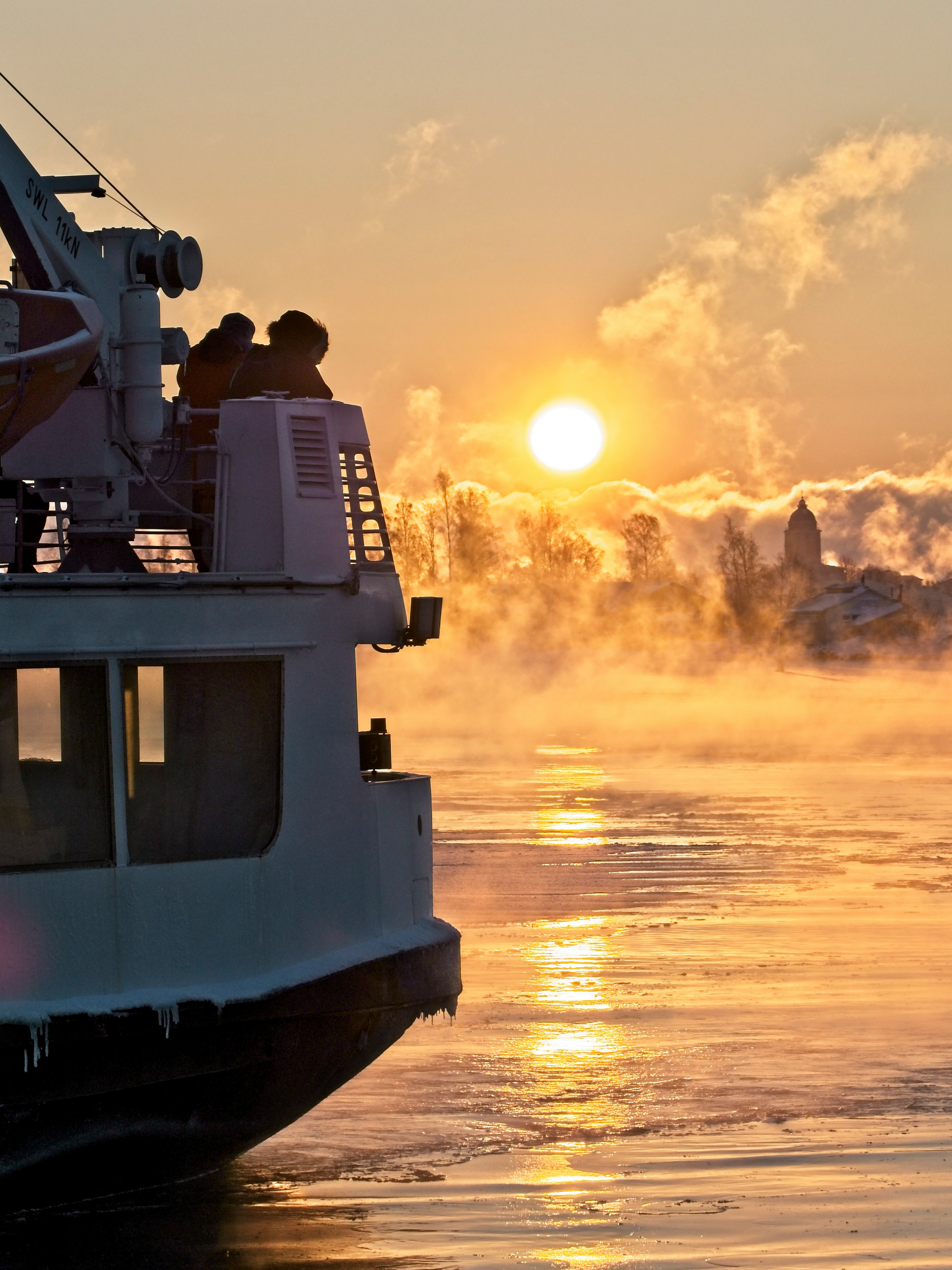 white and black ship on sea during sunset